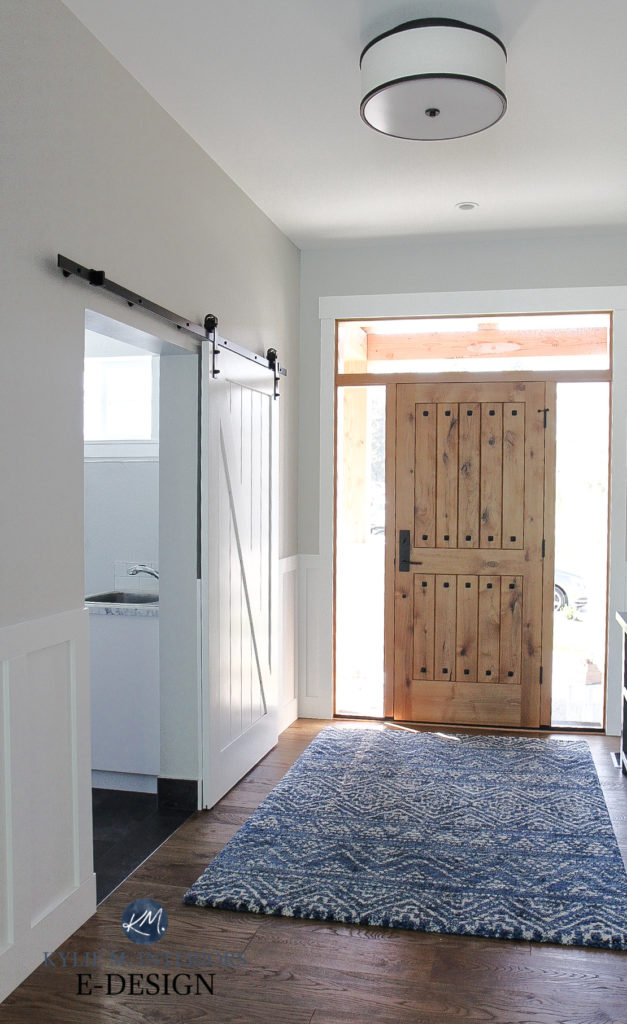 Solid wood custom front door, Benjamin Moore Stonington Gray paint color on walls, oak floor, High Reflective White (Sherwin) trim and board and batten in foyer entryway. Kylie M Interiors Edesign