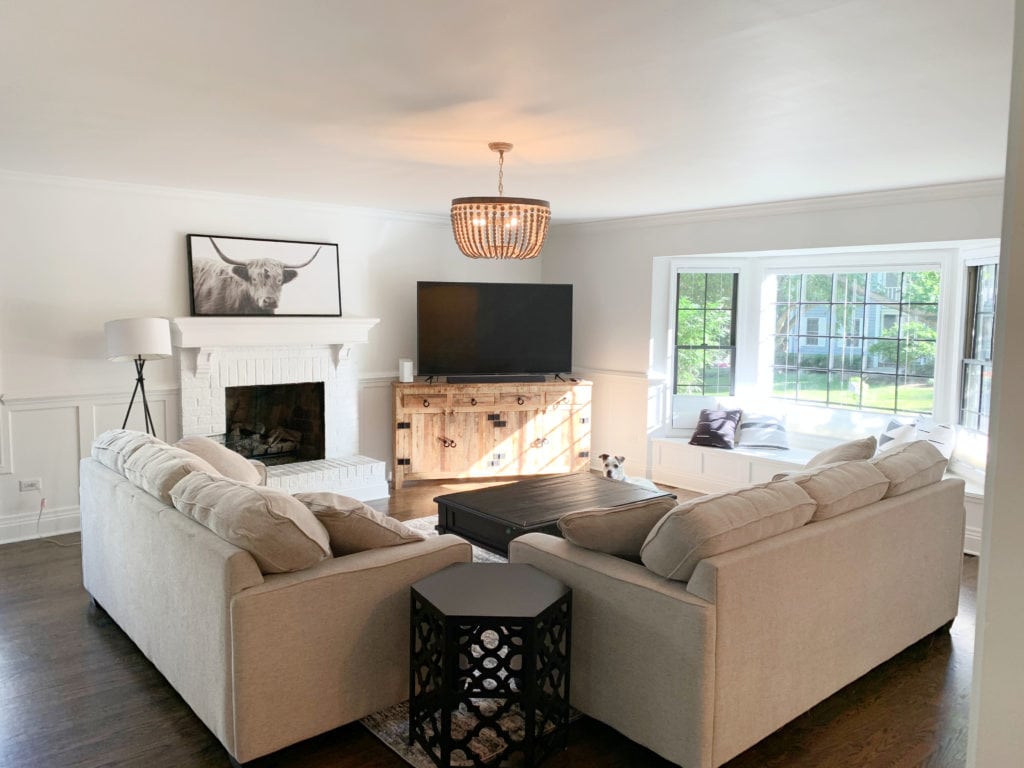 Living room beige sofa and loveseat, wood floor, Sherwin Williams Pure White, best soft white, north east exposure, brick fireplace. Kylie M Interiors client photo