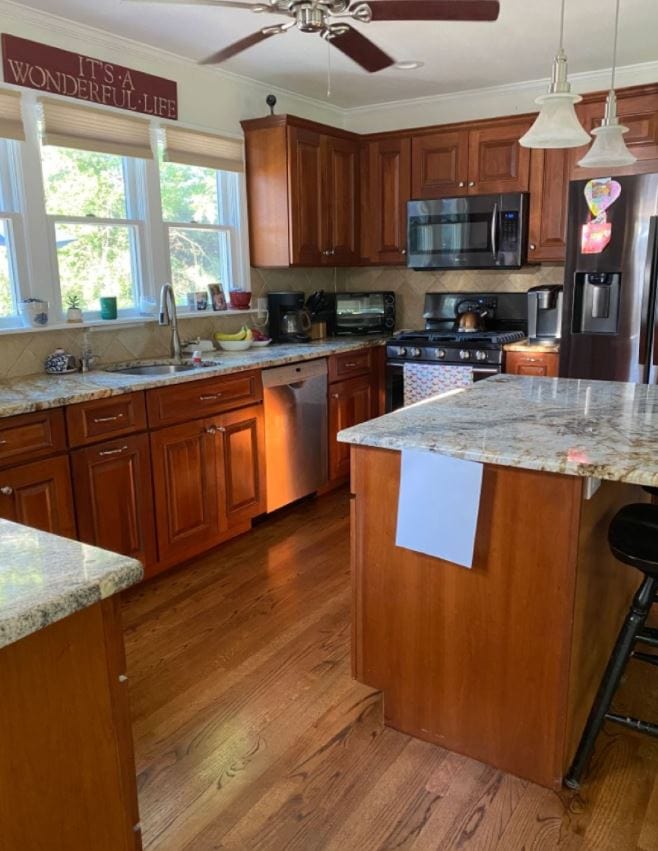 maple or cherry red hue kitchen cabinets (wood) before being painted warm white. Red oak floor. Warm hue granite countertops, travertine look backsplash.