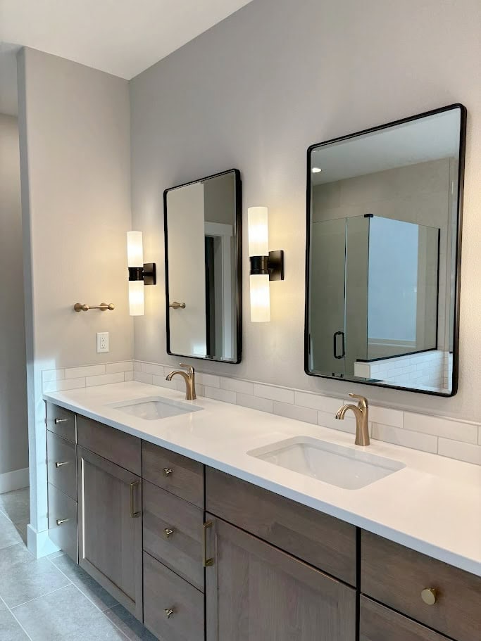 BATHROOM, DOUBLE VANITY, BLACK MIRROR, LIGHTS, GOLD BRASS FAUCET, HARDWARE, WOOD ALDER VANITY, GREIGE TAUPE TILE FLOOR, SHERWIN WILLIAMS AGREEABLE GRAY PAINT COLOR ON WALLS (1)