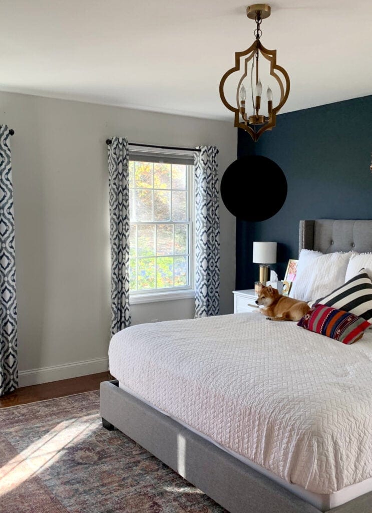 Benjamin Moore Hale Navy accent wall with Silver Satin side walls, gray upholstered bed frame