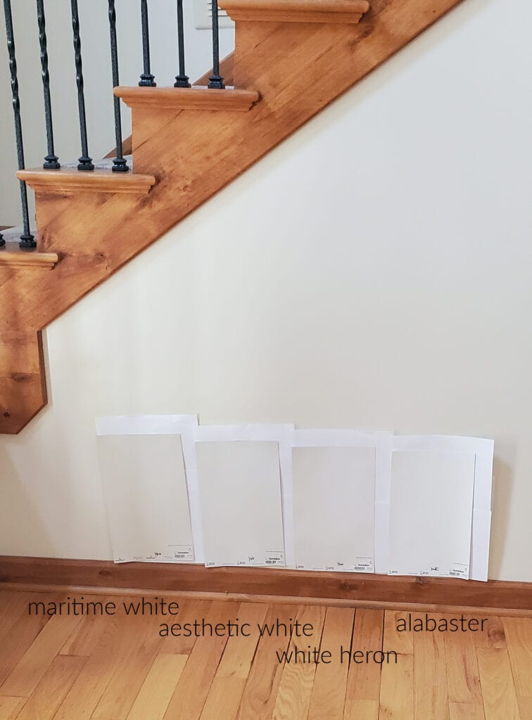Benjamin Moore Maritime White, Sherwin Williams Aesthetic White, White Heron and Alabaster with stairs with orange red cherry wood trim, railing, black spindles, oak or ash floor.