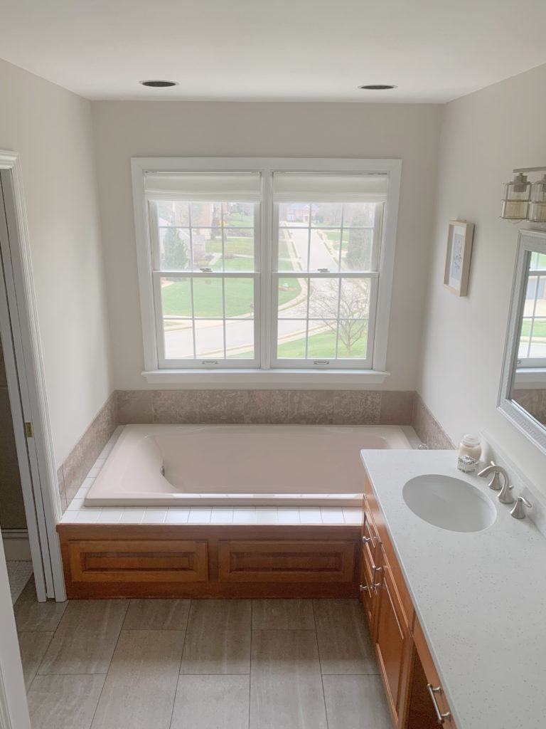 Benjamin Moore Pale Oak in bathrom with pink tub and tile with pink undertones, maple warm hue cabinets. Kylie M Interiors Edesign CLIENT PHOTO before painted vanity
