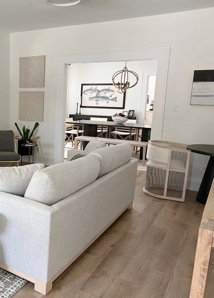 Greek Villa warm white on walls, Sherwin Williams Extra White trim and fireplace surround, neutral furniture, transitional style, wood look floor, shotgun style (2)