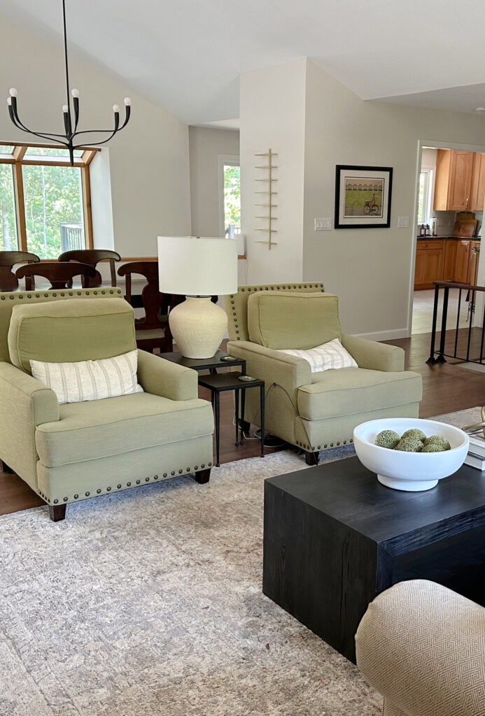 Green accent chairs in open concept split level home, Sherwin Williams White Duck walls, wood trim.