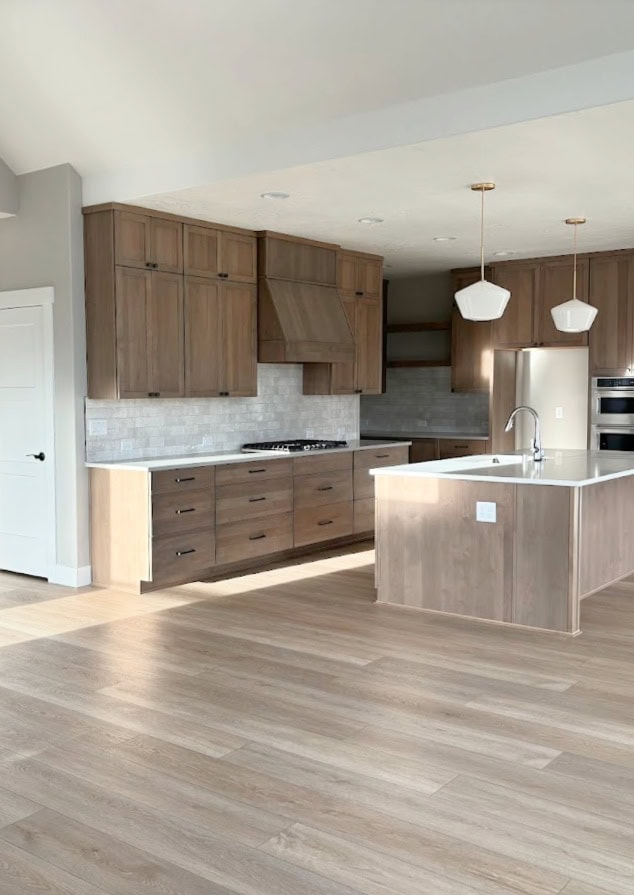 Kitchen with ALDER SIMILAR TO MAPLE stained wood cabinets and island, gray wash wood floor, Sherwin Williams Agreeable Gray walls, Pure White trim, subway tile backsplash