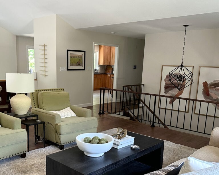 Metal stair railing in split level home with green accent chairs in living room, Sherwin Williams White Duck paint color on walls