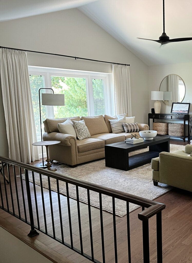 Open concept living room and stairs in split level home, wood floor, vaulted ceiling, Sherwin Williams White Duck paint color on walls, furniture and home decor