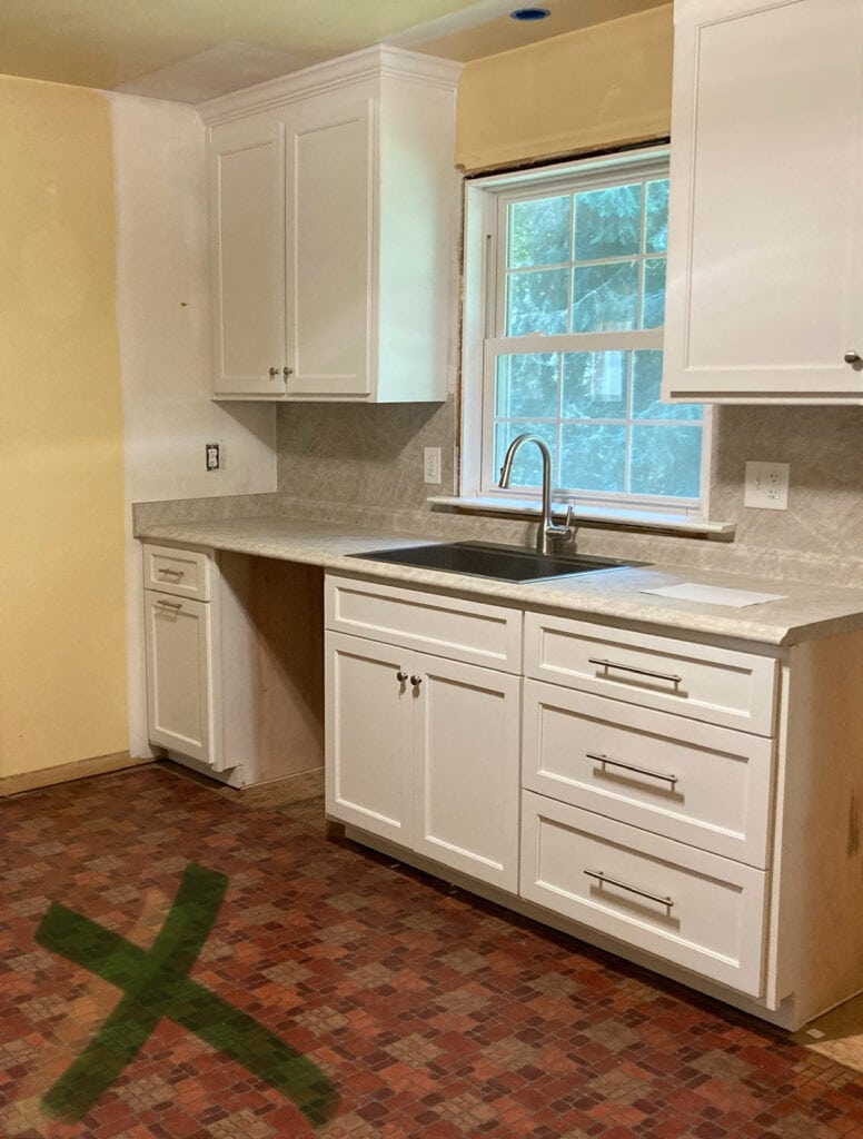 Pure White cabinets and Formica Taj Mahal laminate countertops and counter on backsplash, knobs and handle in polishd nickel, stainless steel kitchen