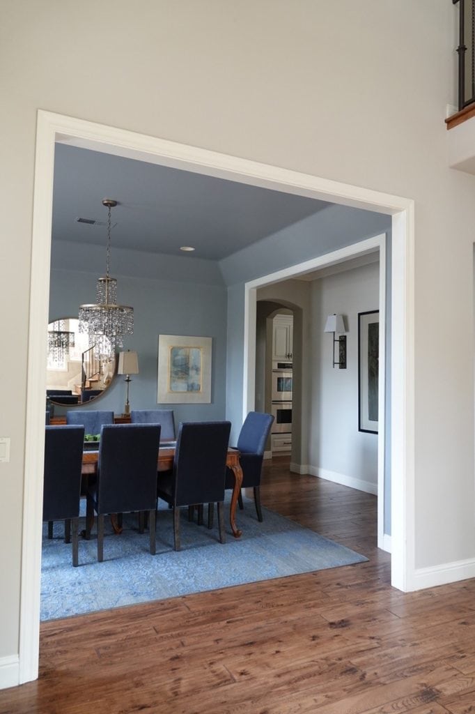 Sherwin Williams Accessible Beige with Benjamin Moore Storm in formal dining room. Blue area rug, orange hue wood floor. Kylie M Interiors, best diy update ideas