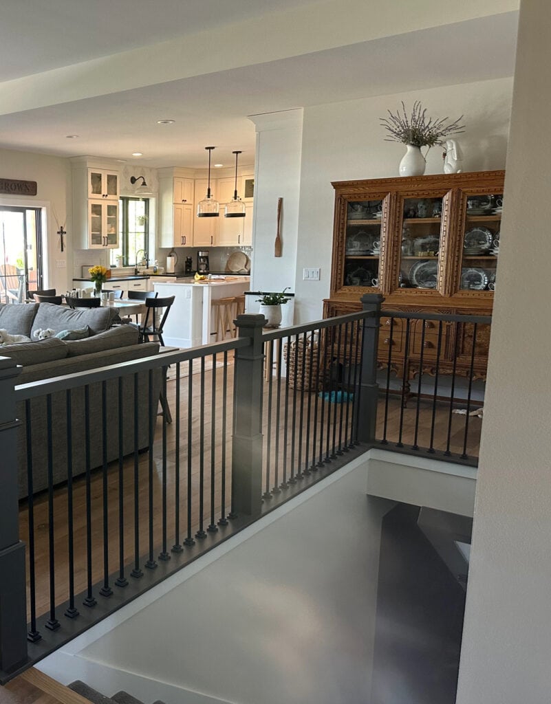 Sherwin Williams Urbane Bronze painted wood stair railing, wood floor, Glacier cabinets, Sherwin Williams White Duck paint color on walls, Pure White trim.