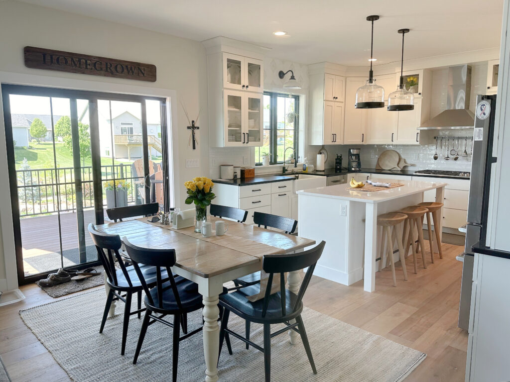 Sherwin Williams White Duck warm off white on walls, Pure White trim, Glacier Wellborn cabinets, Black quartz countertop, white quartz island.