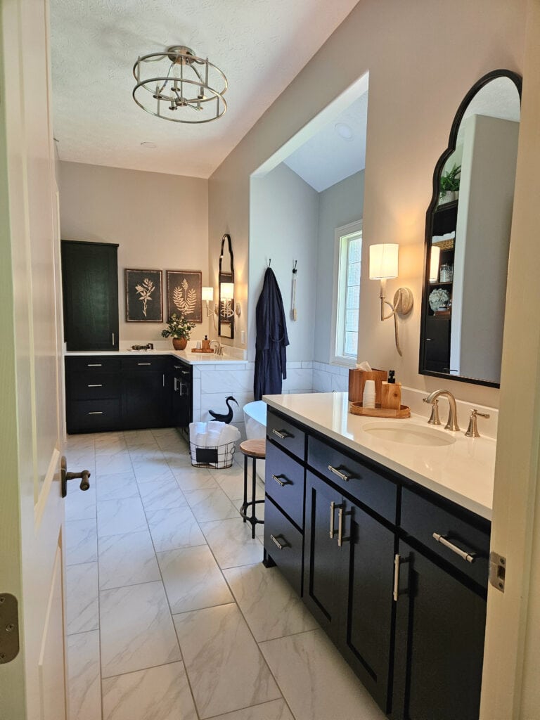 Sherwin Williams Worldly Gray in ensuite, primary bathroom, marble look porcelain tile floor, dark vanity, white quartz countertop
