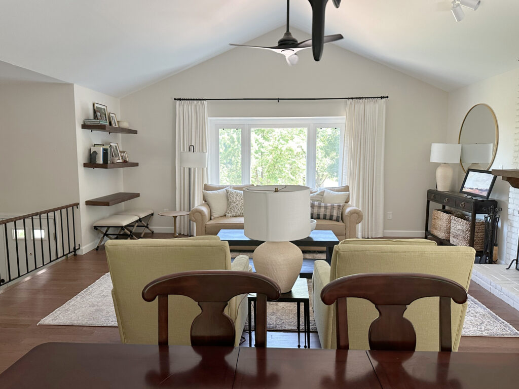 Split level home, living room, vaulted ceiling, painted brick fireplace, dark wood floor, Sherwin Williams White Duck off white on walls, home decor and furniture, black railing