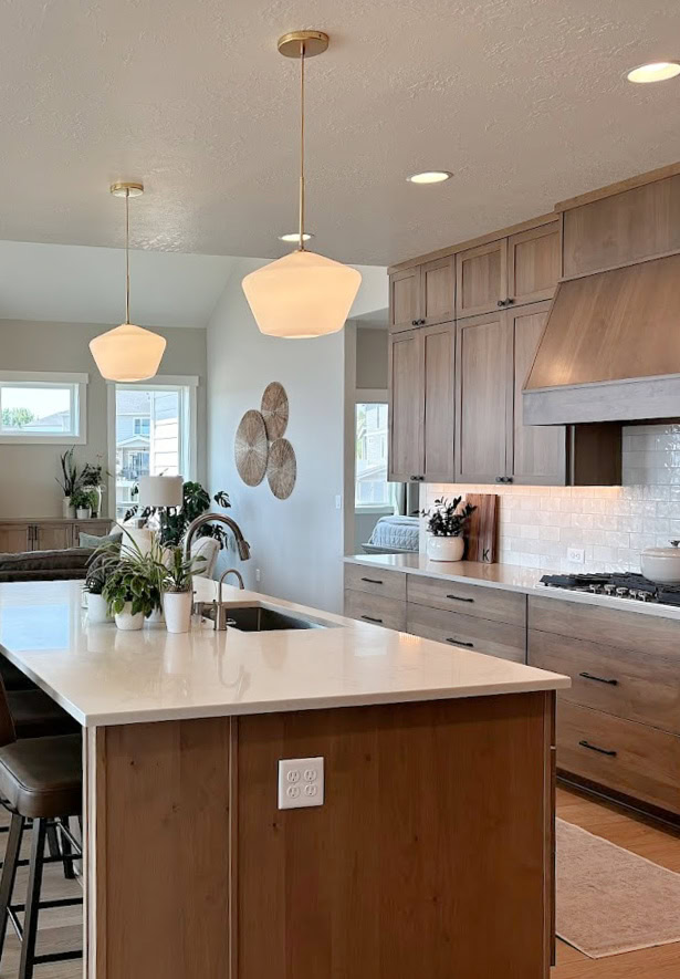 Wood Alder, Oasis stained kitchen cabinets, Enigma quartz on wood island, gold pendant lights