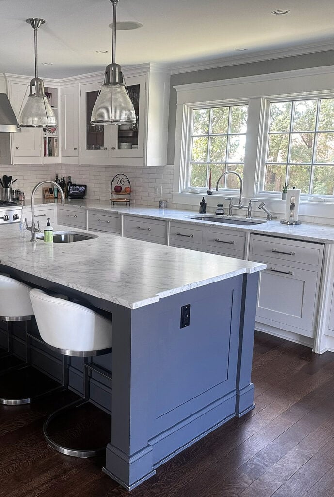 dark blue gray painted kitchen island, dark wood stained oak floor, marble countertop, cool white painted cabinets, chrome