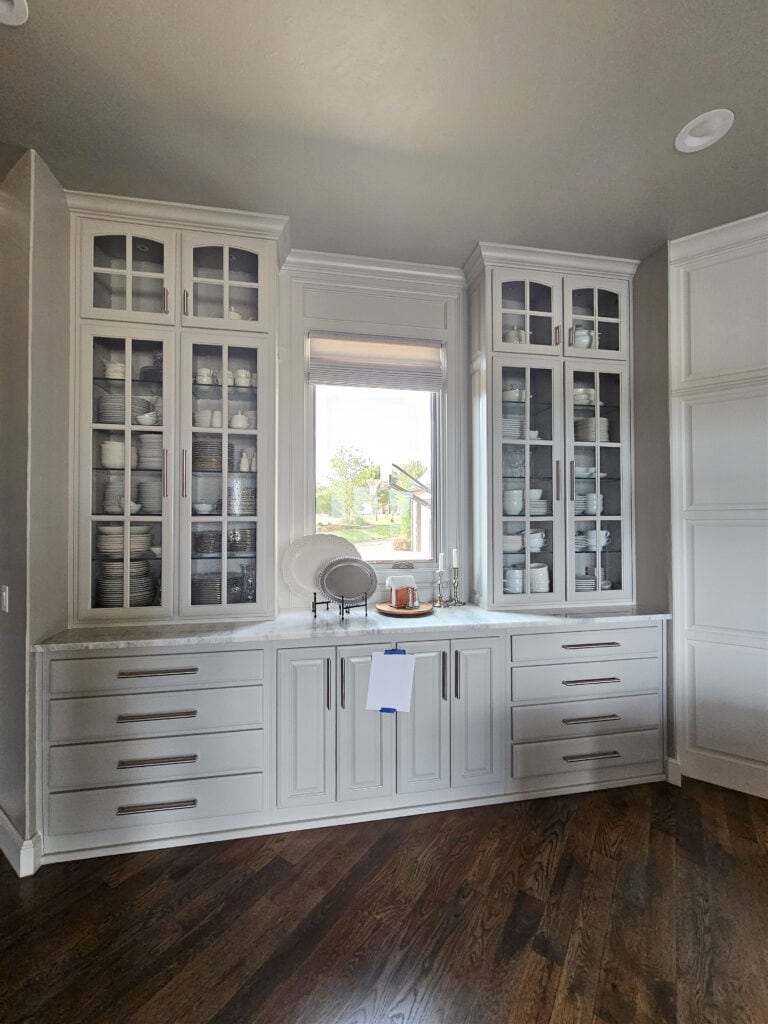 kitchen pantry, glass front cabinets, quartzite countertops that look like marble, painted Sherwin Williams light french gray, dark oak wood floor