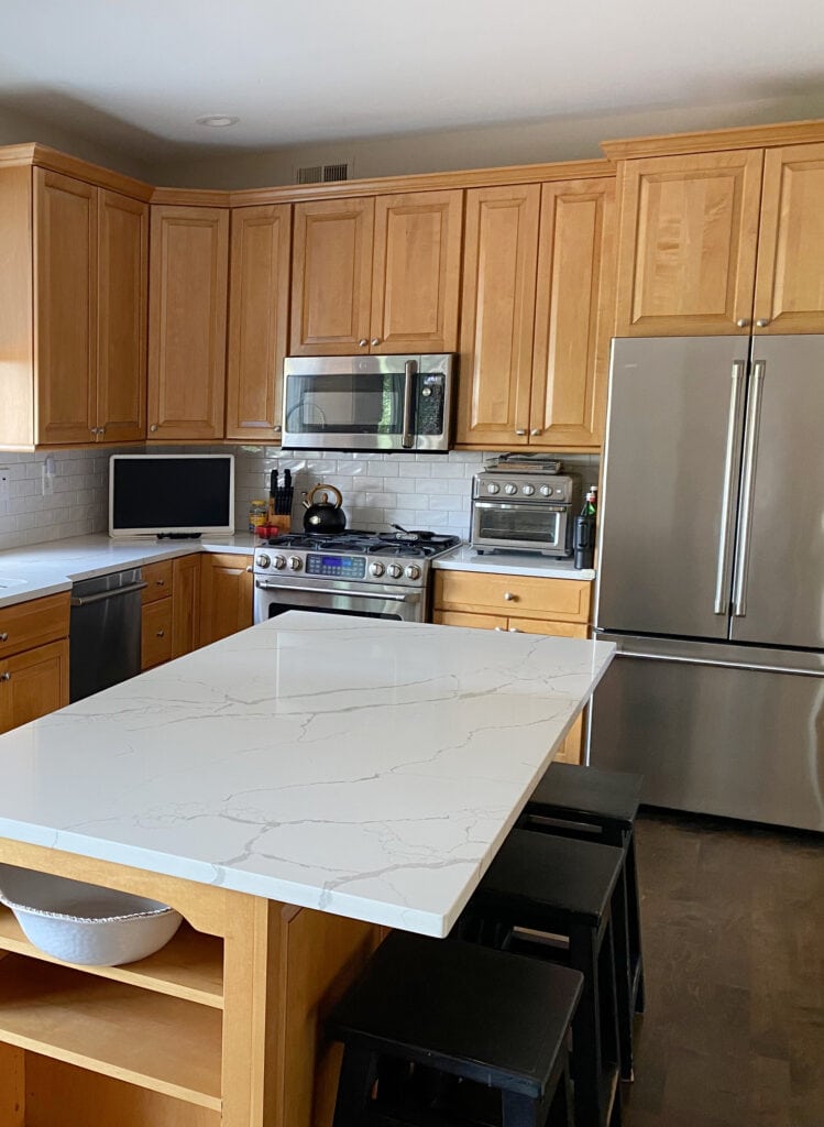 kitchen with maple wood cabinets, white subway tile backsplash, Calacatta Laza MSI white quartz countertop, stainless steel appliances