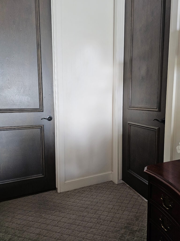 taupe greige carpet with dark wood stained interior doors, off-white trim and walls in Sherwin Williams Heron Plume