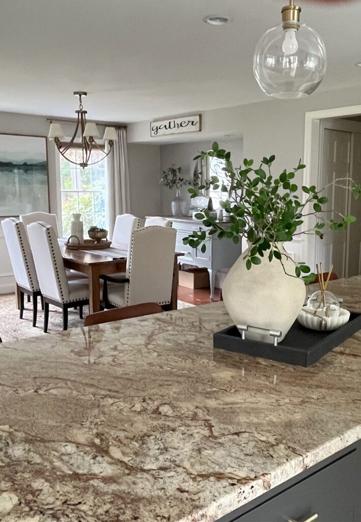 Dining room painted in Sherwin Williams Worldly Gray, greige paint color, granite countertop, Urbane Bronze painted kitchen wood island