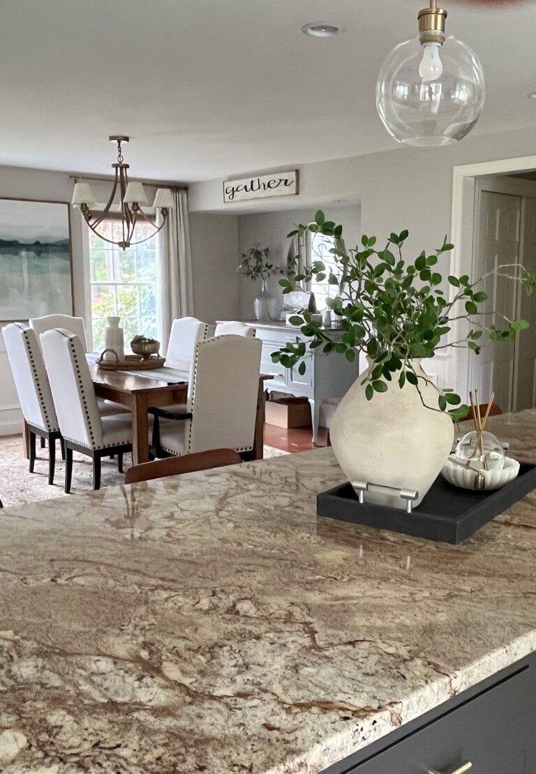 Dining room painted in Sherwin Williams Worldly Gray, greige paint color, granite countertop, Urbane Bronze painted kitchen wood island