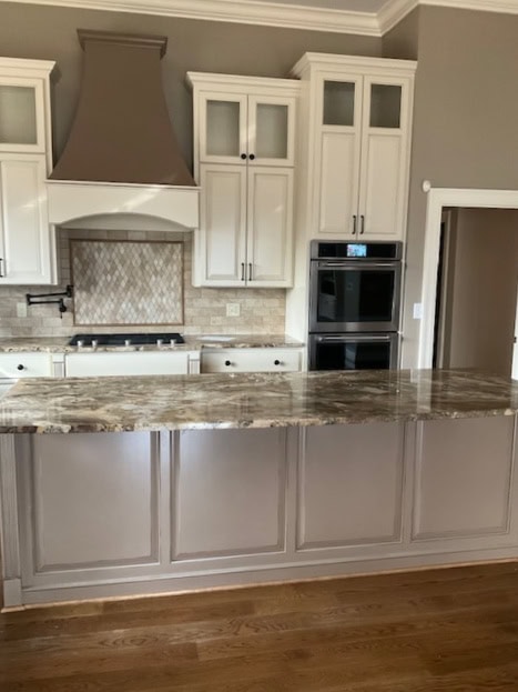 Navajo White cream painted kitchen cabinets with darker taupe greige island and granite countertops. Wall colour a medium warm neutral.