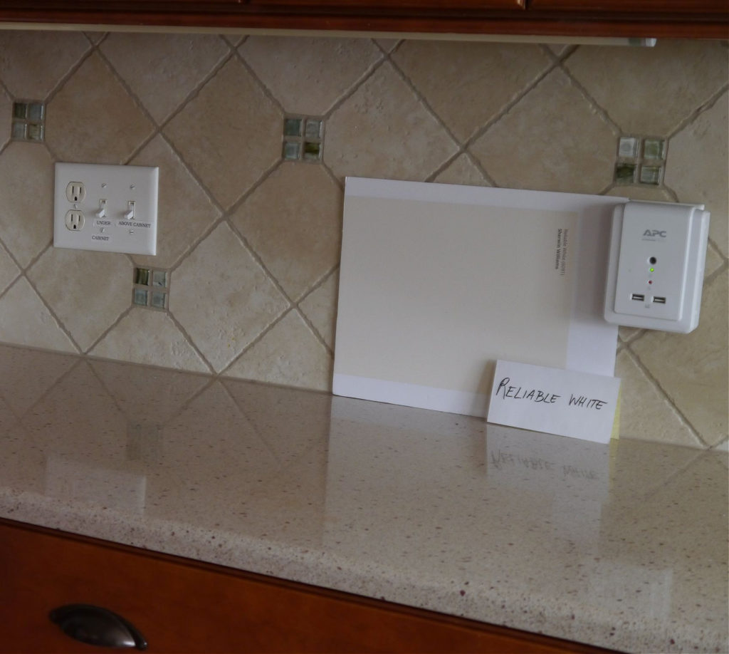 Sherwin Williams Reliable White in kitchen with cherry cabinets, beige countertop, beige backsplash tile. Kylie M Interiors Edesign