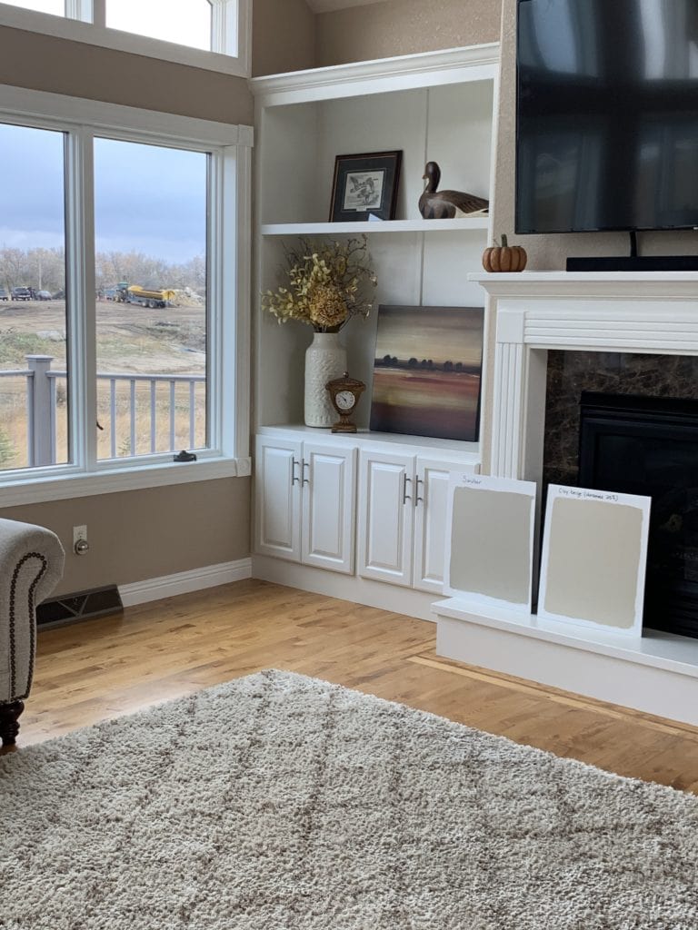 Sherwin Williams Sandbar and Benjamin Moore Clay Beige with warm white fireplace surround and built in cabinets. Kylie M Interiors Edesign