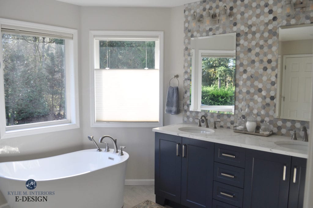 Blue vanity similar Benjamin Moore Hale Navy. Bathroom, freestanding white tub, , beige, blue white hexagon tile vanity backsplash, Sherwin Williams Egret White paint on walls.