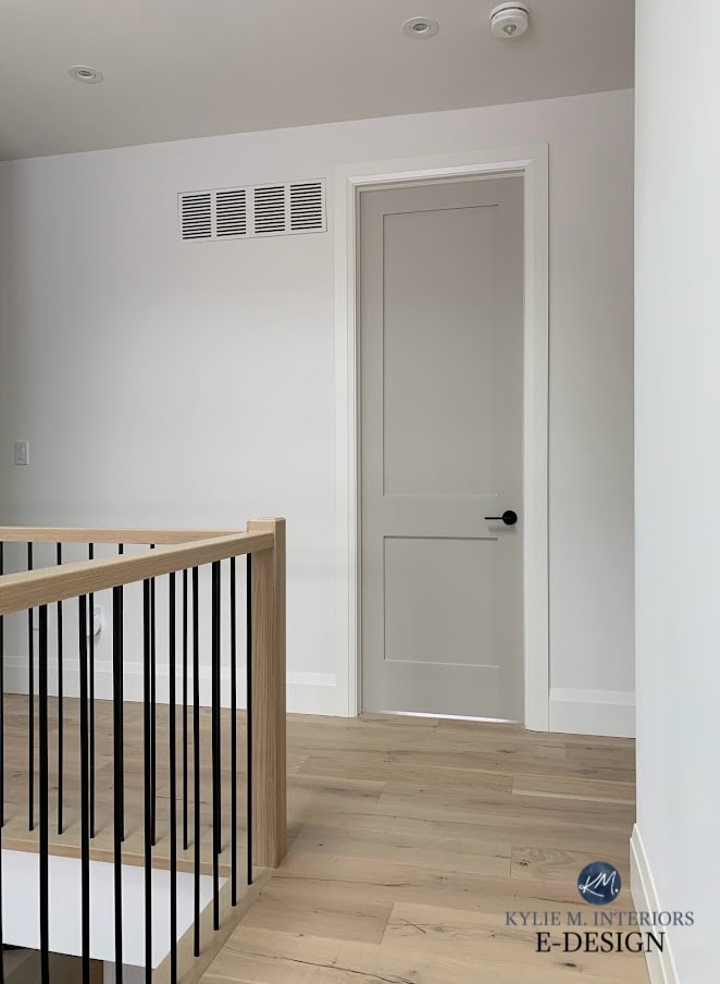 Stair railing, oak hand railing, black metal spindles, white oak floor, Benjamin Moore Revere Pewter interior doors, White Doe walls and trim. Kylie M Interiors Edesign