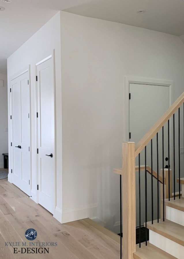 Wood stair railing, black metal spindles, walls Benjamin Moore White Dove, black hardware, white oak flooring. Kylie M Interiors Edesign