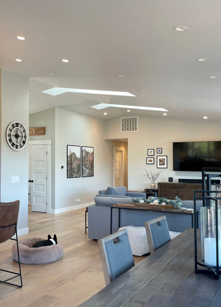 Open concept great room or living room with Sherwin Williams Repose Gray, light wood flooring. Kylie M.