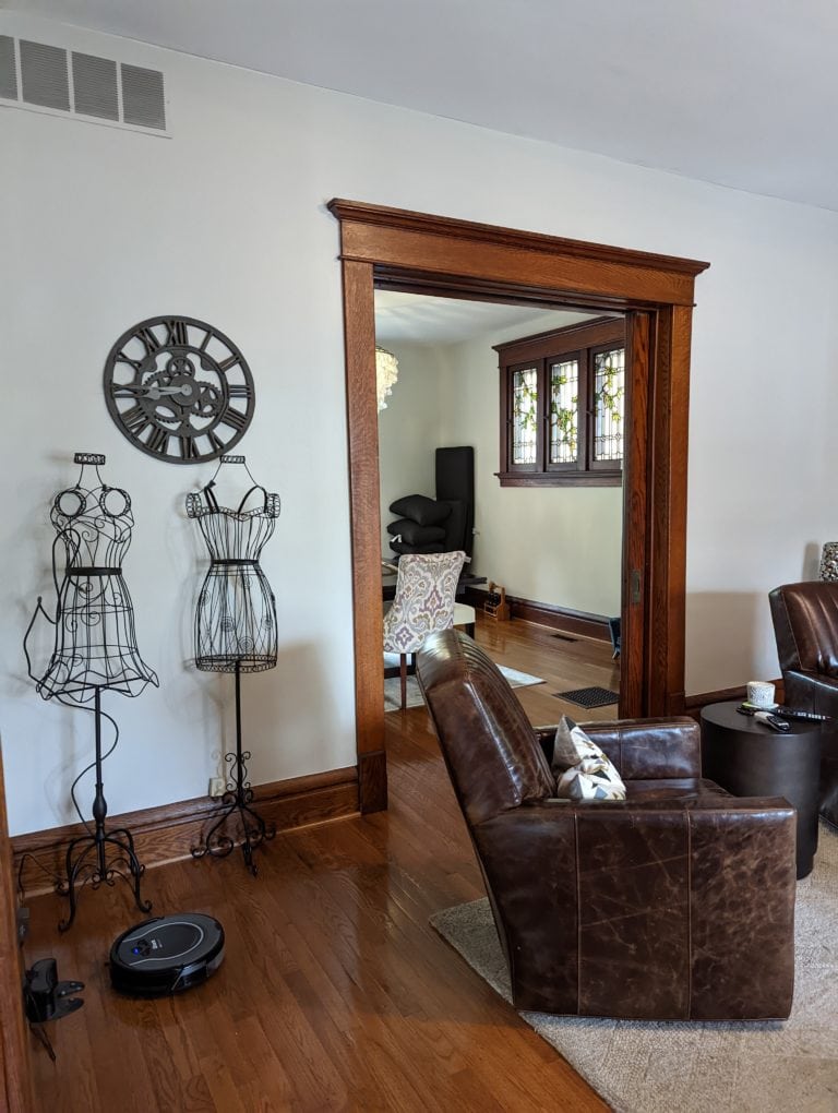 Sherwin Williams Agreeable Gray in BRIGHT light room with dark wood trim and flooring. Kylie M.