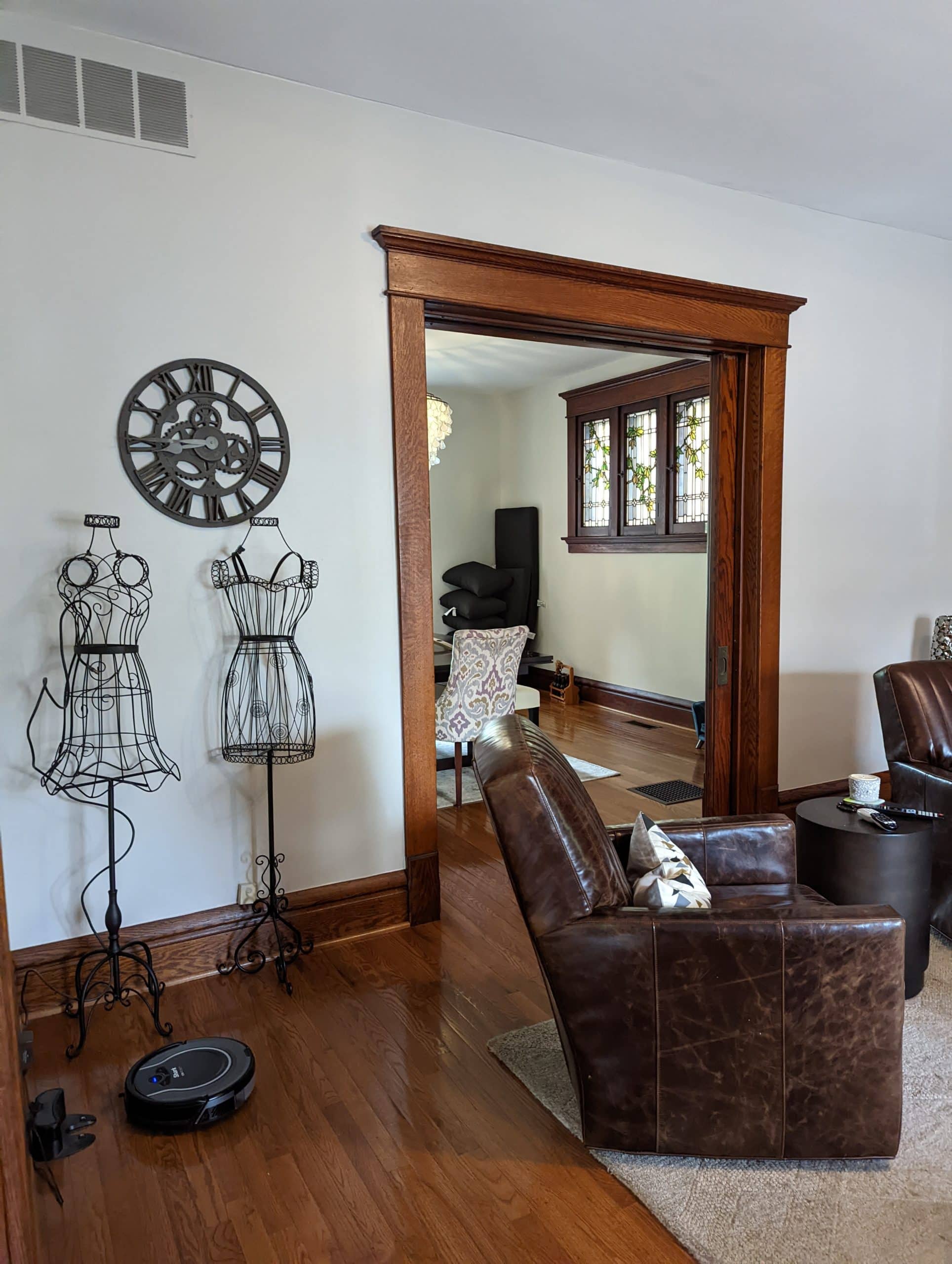 Sherwin Williams Agreeable Gray in BRIGHT light room with dark wood trim and flooring. Kylie M.