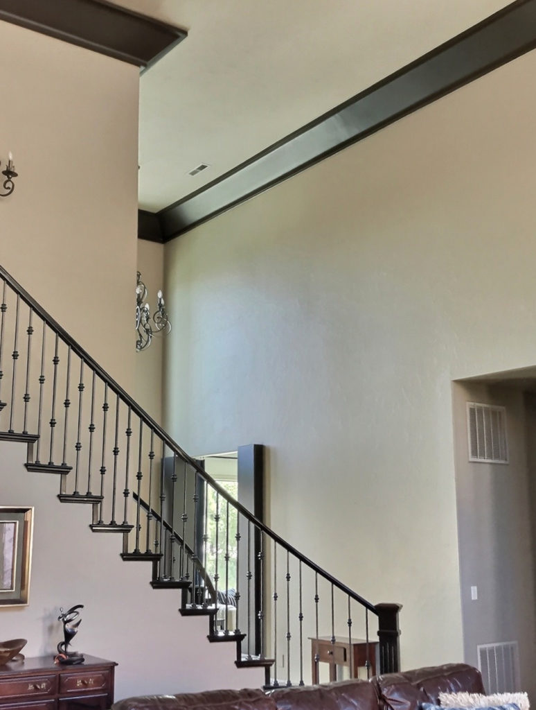 Sherwin Williams Tony Taupe, dark wood stair railing, warm paint color on walls.