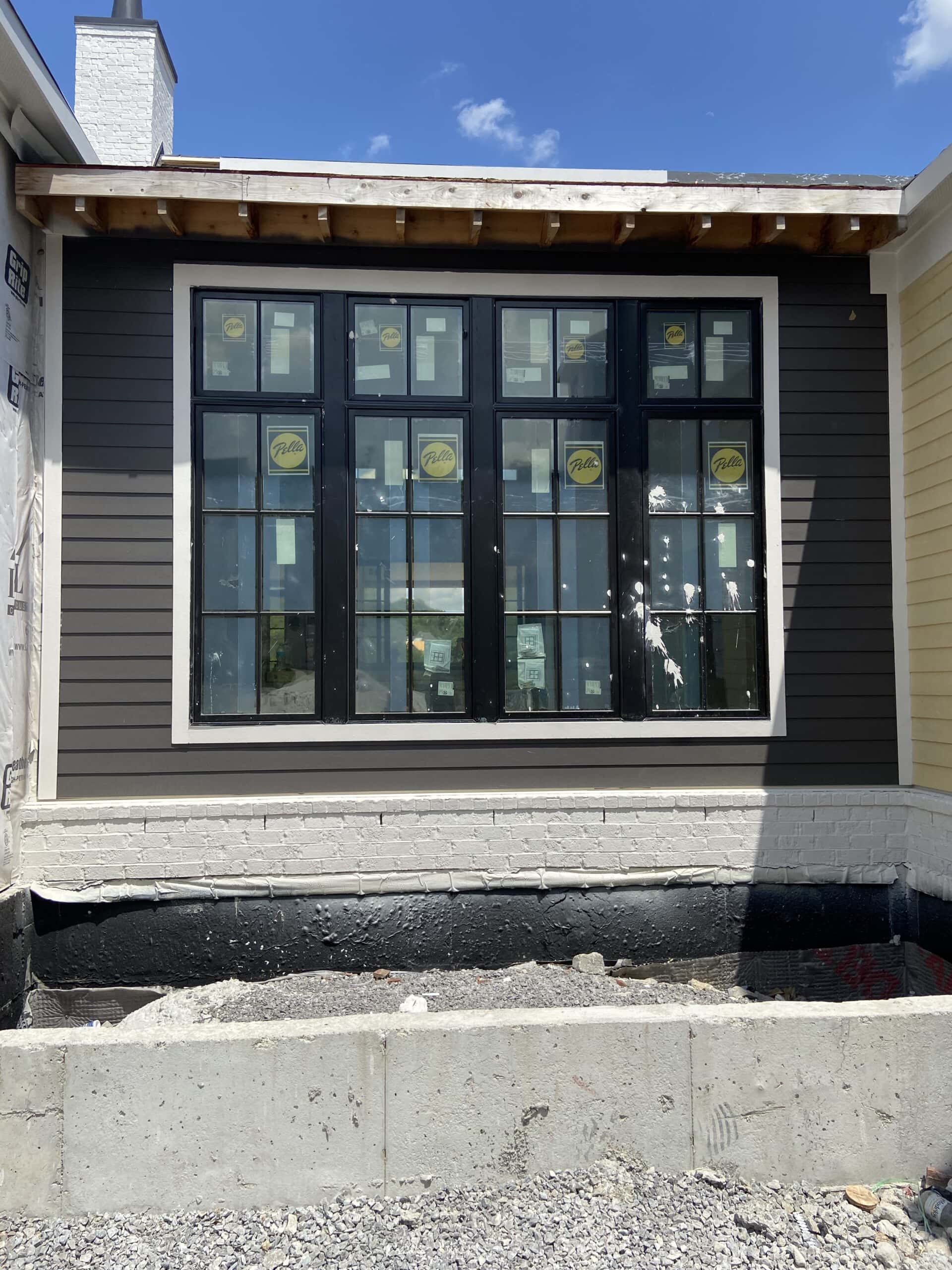 Benjamin Moore Iron Mountain on exterior siding in sun with black windows.