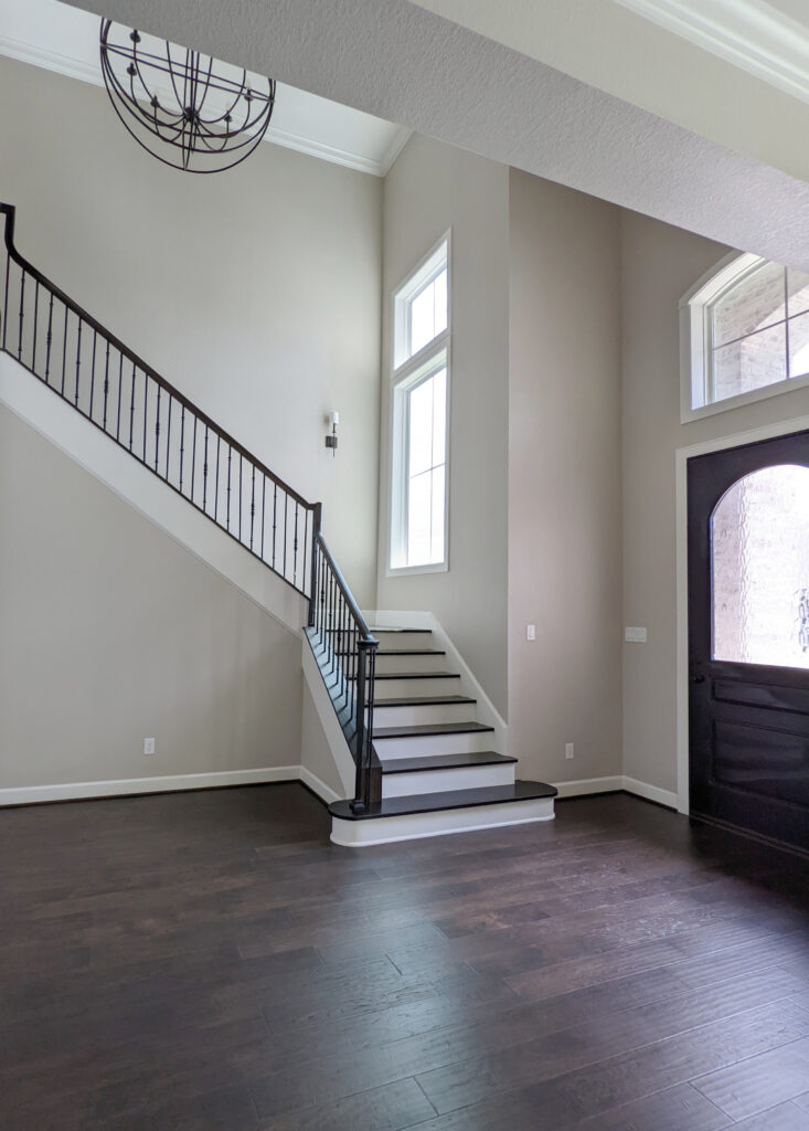 Entryway, stairs, Sherwin Williams Accessible Beige, Benjamin MOore White Dove, dark wood flooring and railing.Update ideas for 2000s staircase. Kylie M design blog