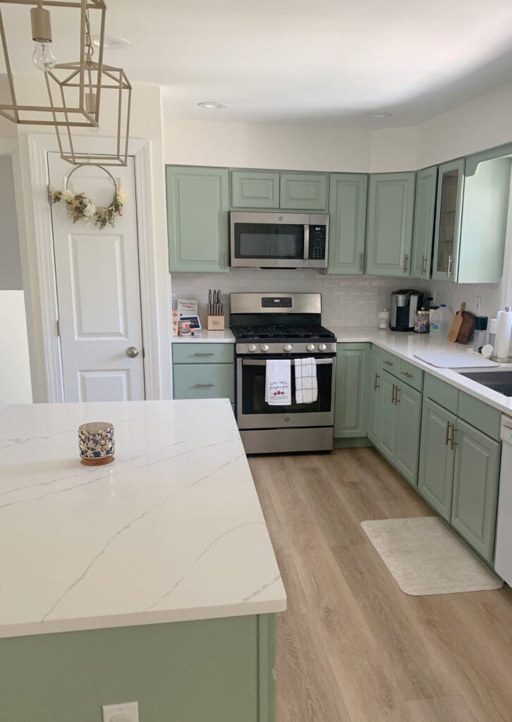 White washed wood floor Kitchen cabinets and island painted Sherwin Williams Cascade Green, white quartz countertop, Cloud White walls. Kylie M paint color blogger