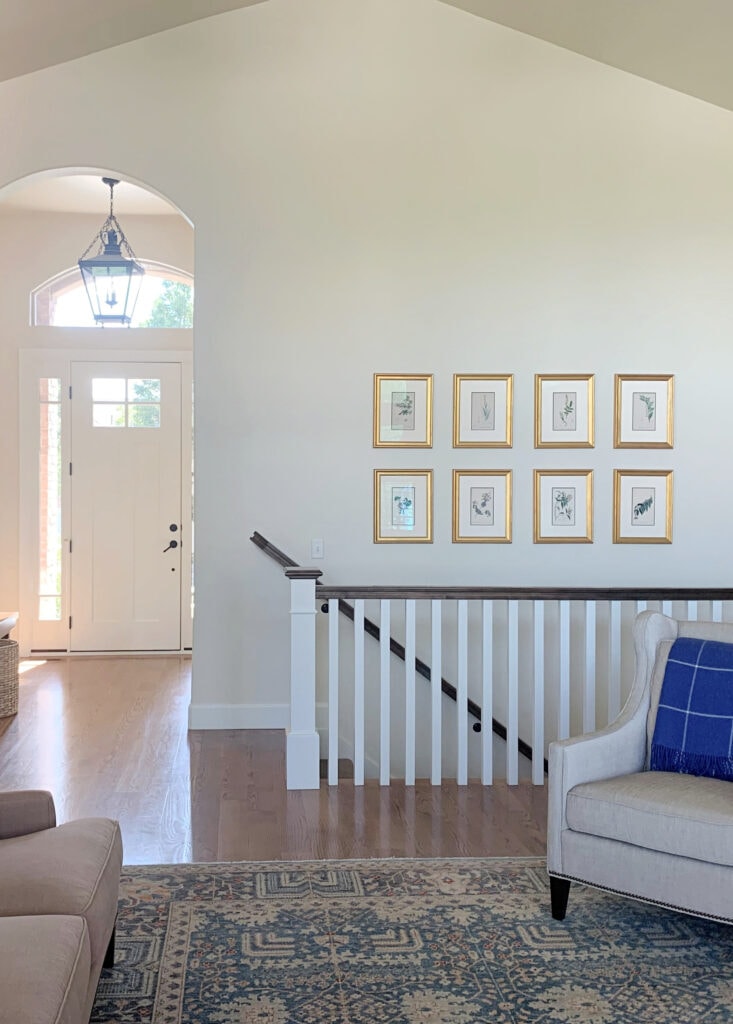 Sherwin Williams Antique White warm cream paint color on walls, vaulted ceiling, wood floor. Kylie M Paint color blogger