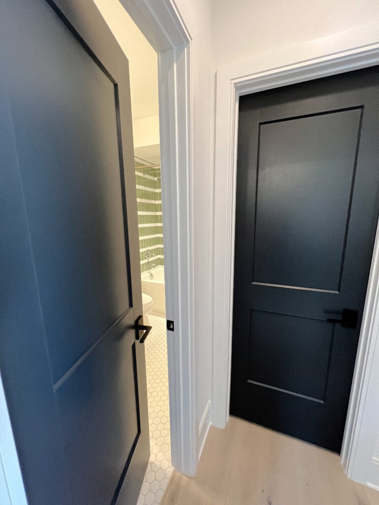 Wrought Iron painted black navy blue interior doors with Eider White walls white trim. Kylie M