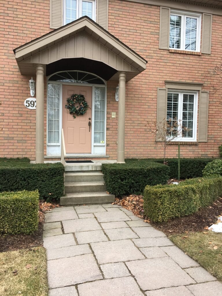 Benjamin Moore Alexandria Beige trim, earth toned coral front door, red orange pink brick exterior and stone. Kylie lM