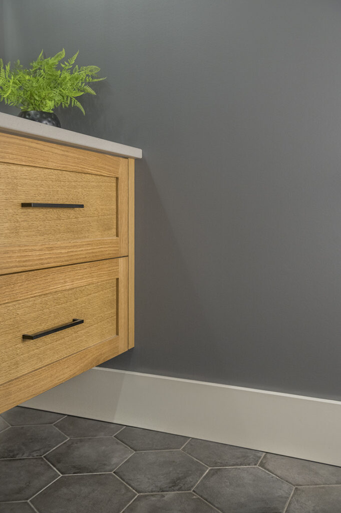 Black hexagon tile floor, oak wood vanity, concrete look countertop, Benjamin Moore Stormy Sky best dark gray paint color. Kylie M Edesign.