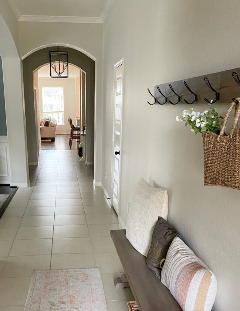 Long hallway foyer, beige off white tile floor, Benjamin Moore Edgecomb Gray 25 lightened, arched doorway
