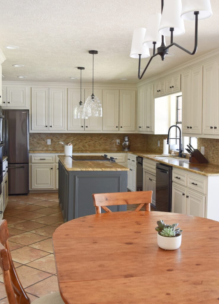 Kitchen, painted cabinets, orange tile floor, travertine tile, granite coutnertops, off-white beige cabinets, Sherwin Williams Moderate White. Kylie M Edesign