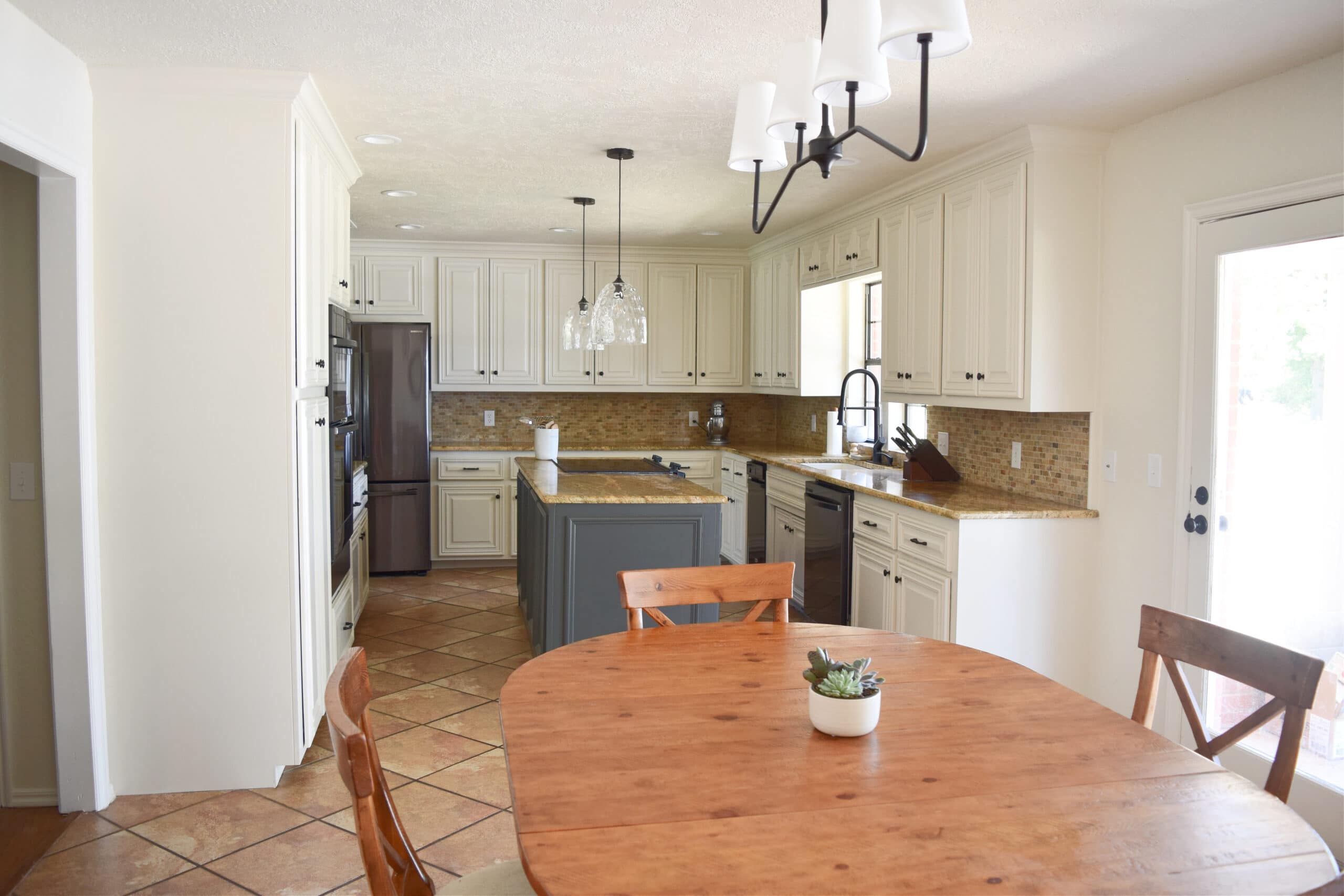 Kitchen remodel painted wood cabinets, Sherwin Williams Moderate White, travertine, orange tile floor, granite countertop, black stainless steel appliances. Ashwood Moss