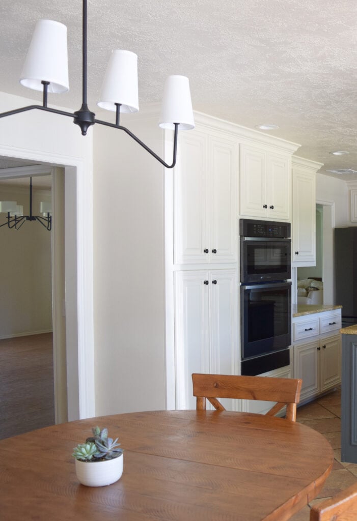Sherwin Williams Moderate White, 50 lighter on trim, black stainless appliances. painted wood cabinets. Best off white beige paint color. Kylie M Edesign