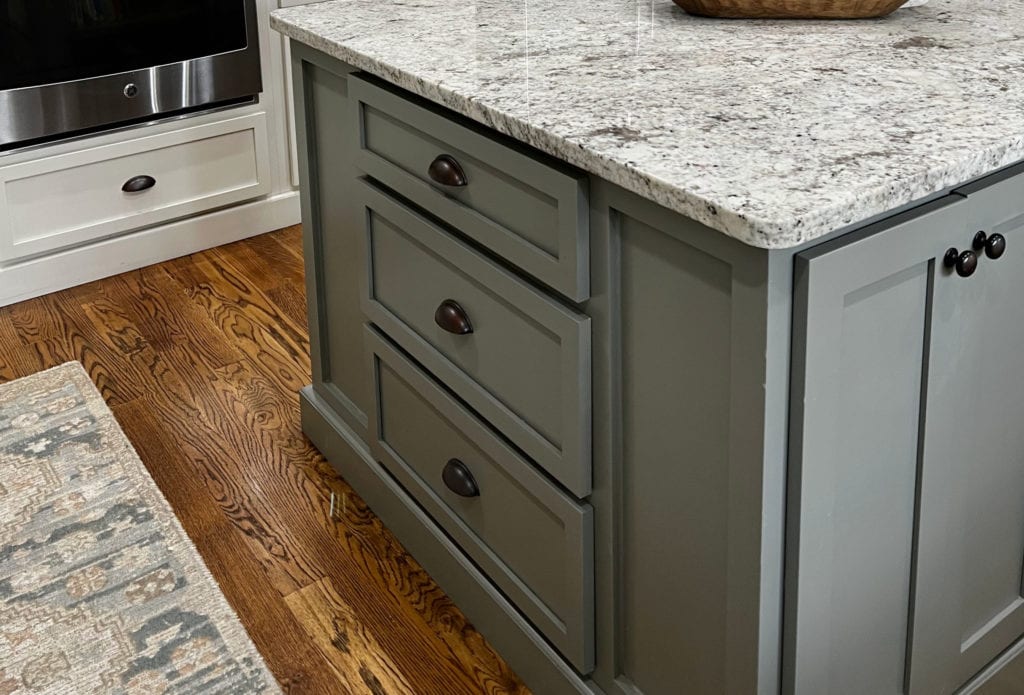 Benjamin Moore Chelsea Gray paint color on painted island with granite flecked countertop, warm oak wood flooring in kitchen