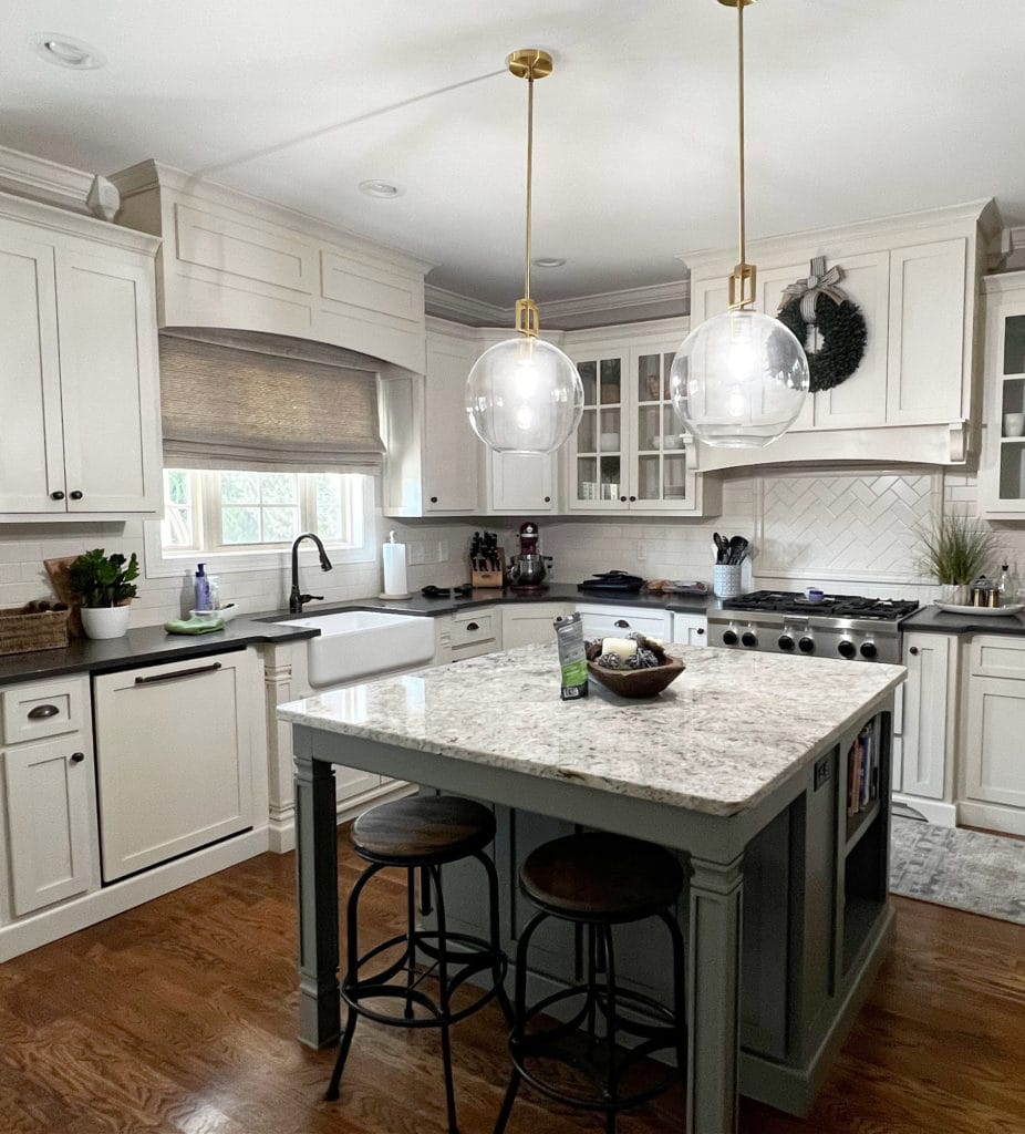 Cream painted kitchen cabinets, Benjamin Moore Linen White, island Chelsea Gray, black granite and speckeld granite island, oak flooring. Kitchen update