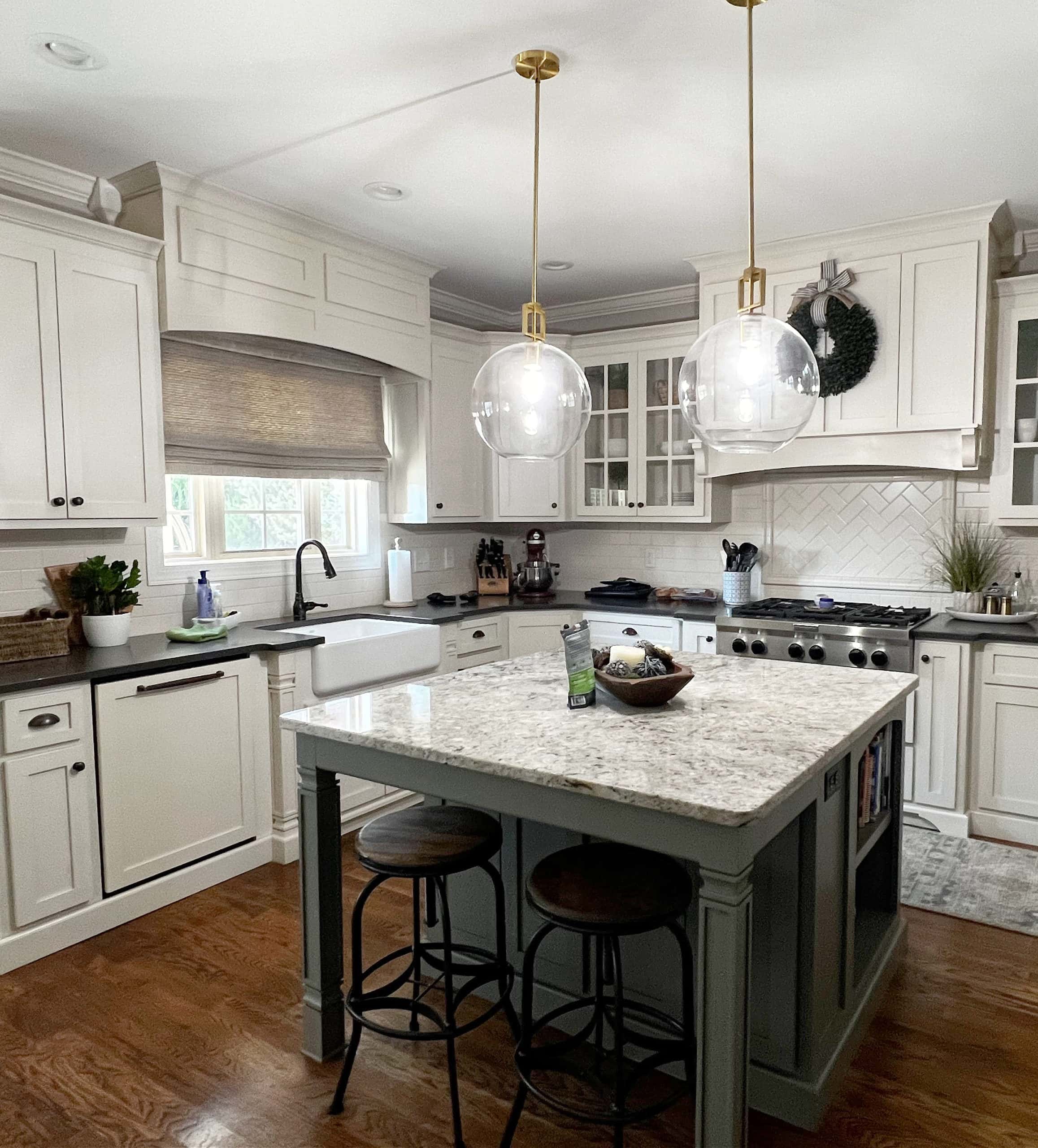 Cream painted kitchen cabinets, Benjamin Moore Linen White, island Chelsea Gray, black granite and speckeld granite island, oak flooring. Kitchen update