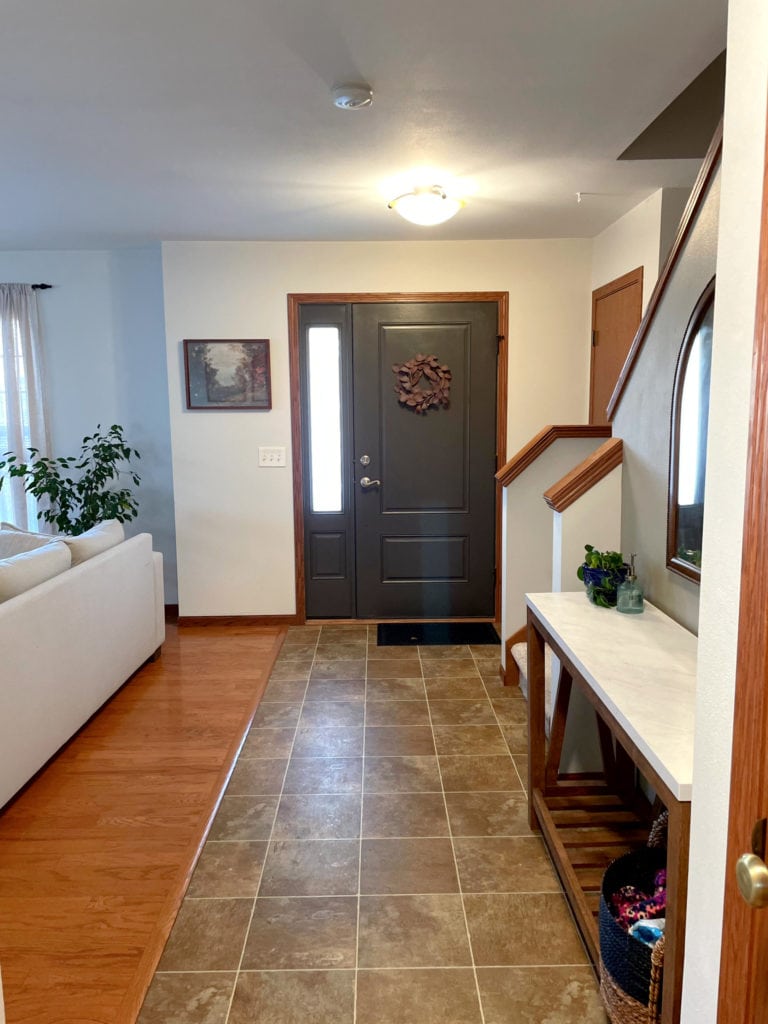 Sherwin Williams Aesthetic White paint color on walls, wood trim, wood floor, URbane Bronze painted inside of front door
